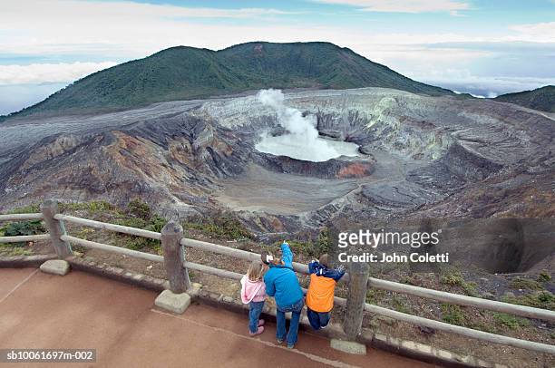 costa rica, poas national park, mother with children (4-11) watching steam rising from poas volcano - poas national park stock pictures, royalty-free photos & images