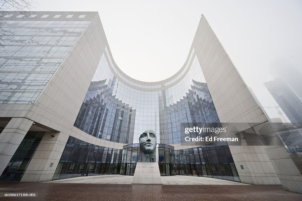 Statue of human face in front of office building