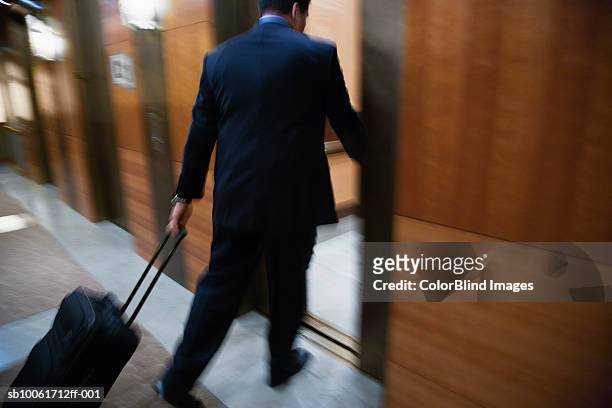 businessman with luggage, running towards elevator - lobby closed fotografías e imágenes de stock