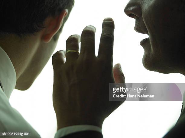 businessman whispering another businessman, close-up - gossip stock pictures, royalty-free photos & images