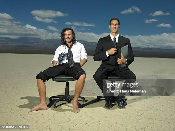 two businessmen sitting on office chair in desert, smiling, portrait - laptop desert stock pictures, royalty-free photos & images