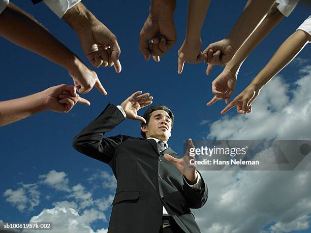 businessman with fingers pointing at him, low angle view - biasimo foto e immagini stock