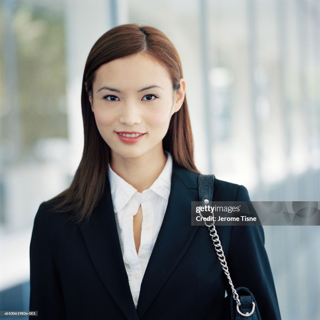 Young businesswoman outdoors, smiling, portrait, upper half