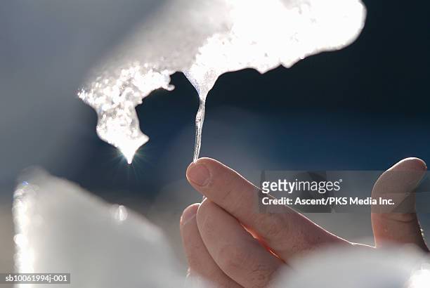 person touching icicle, close-up - icicle stock-fotos und bilder