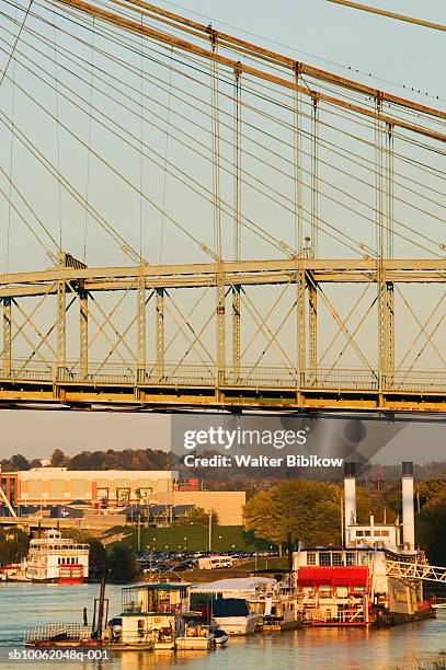 usa, kentucky, covington, roiling suspension bridge and riverboats on ohio river - covington kentucky stock pictures, royalty-free photos & images