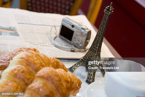 newspaper, digital camera, eiffel tower souvenir and croissants on table - eiffel tower cafe stock pictures, royalty-free photos & images