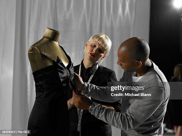 couple standing in front of mannequin with measuring tape - backstage fashion stock pictures, royalty-free photos & images