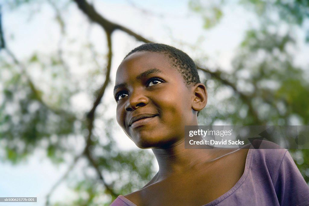 Girl (8-9) looking away, smiling, close-up
