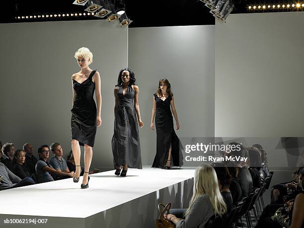 spectators watching fashion models on catwalk - fashion show runway stock pictures, royalty-free photos & images