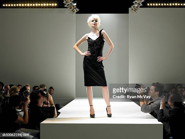 paparazzi photographing fashion model on catwalk - fashion show stockfoto's en -beelden
