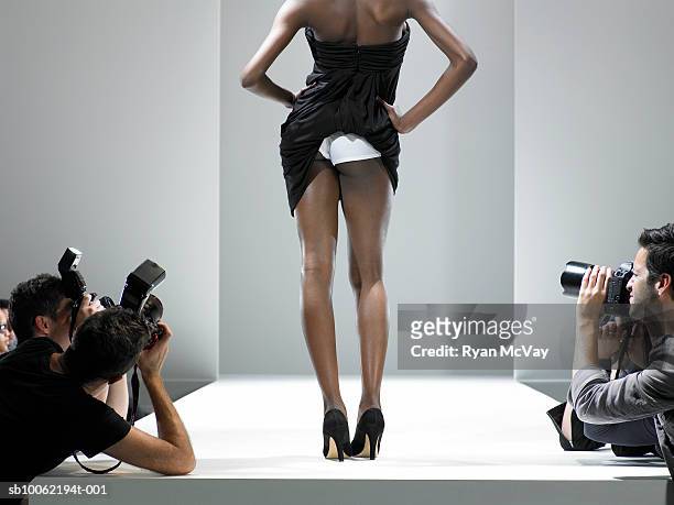 paparazzi photographing fashion model showing underwear, on catwalk - paparazzi photographer imagens e fotografias de stock