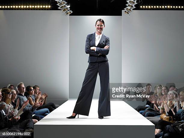 spectators applauding female fashion designer on catwalk - défilé photos et images de collection