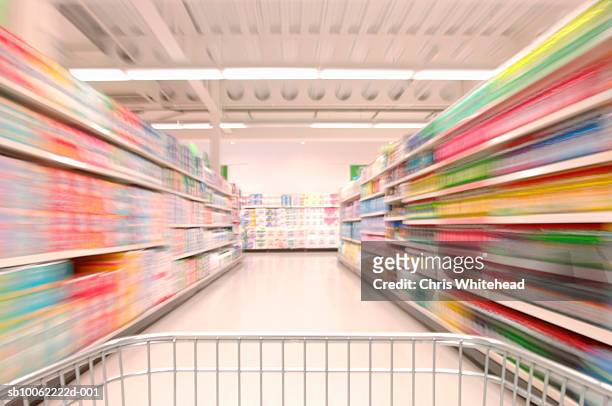 supermarket trolley being pushed up aisle, blurred motion - travée photos et images de collection