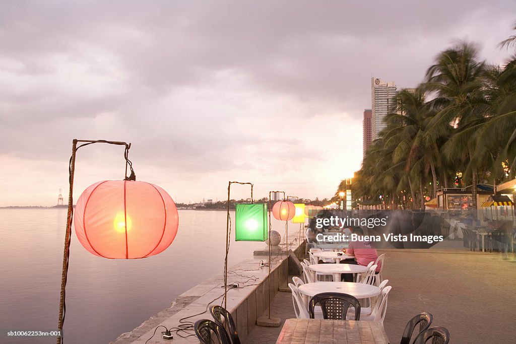 Lamps at sunset in restaurant on waterfront over Manila Bay