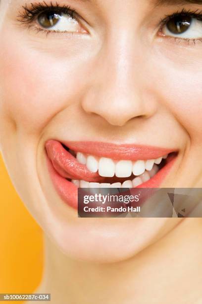 young woman looking away and smiling, licking lips, close-up - woman lips stock pictures, royalty-free photos & images