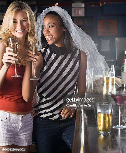 two young woman holding champagne flute, smiling - 男性告別單身派對 個照片及圖片檔