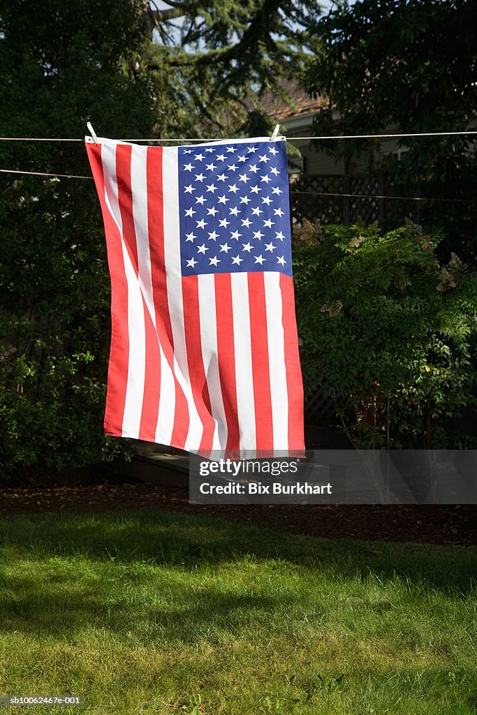 American flag hanging on clothesline in backyard