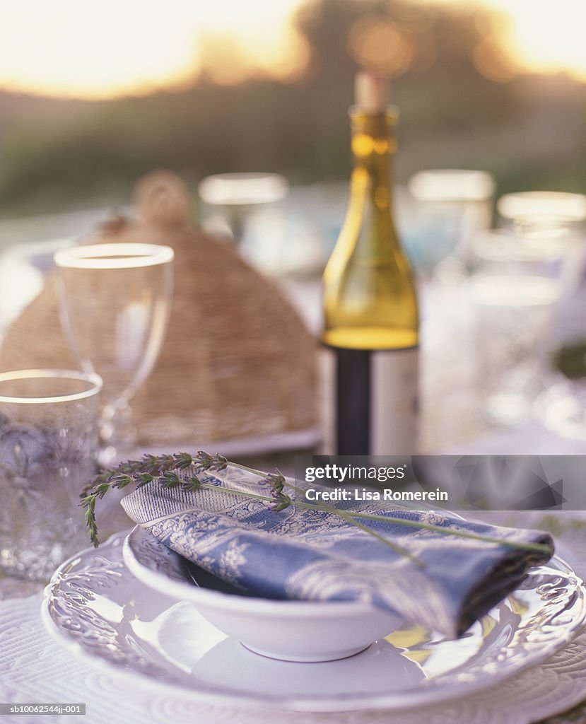 Table setting and bottle of red wine