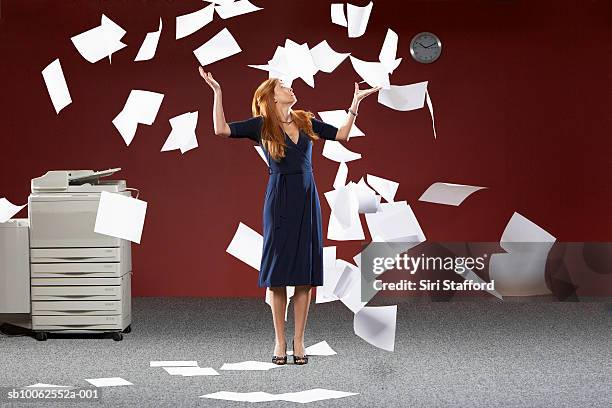 woman throwing sheets of papers in air - throwing foto e immagini stock