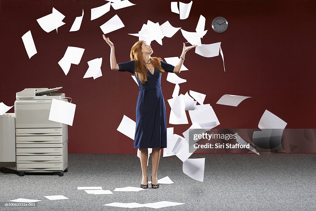 Woman throwing sheets of papers in air