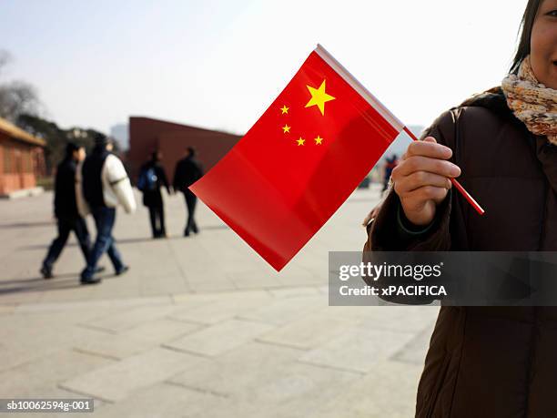 woman holding chinese flag on street - china flag stock pictures, royalty-free photos & images