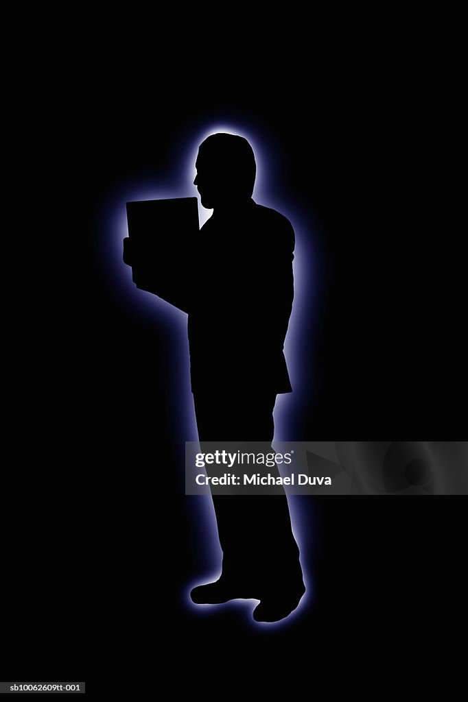 Silhouette of man holding file