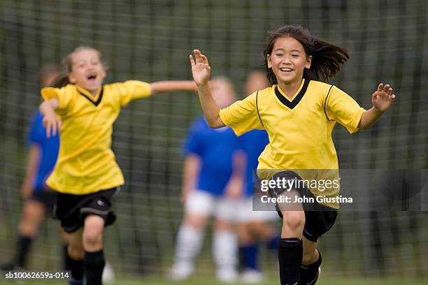 girls (8-9) playing football (differential focus) - goal net stock pictures, royalty-free photos & images