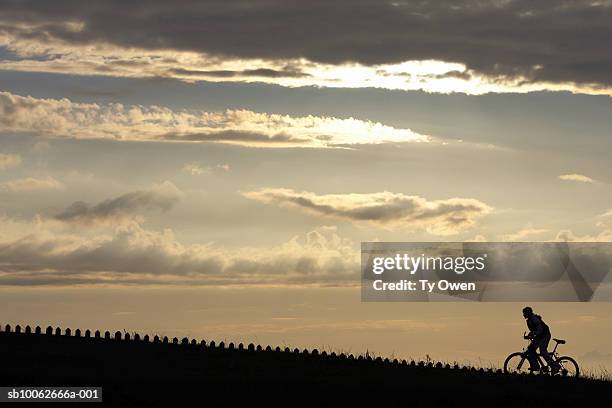 a person rides a bycycle uphill. - wt1 stock pictures, royalty-free photos & images