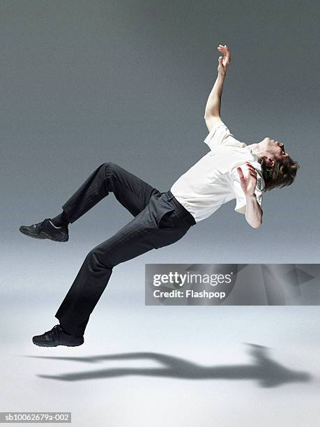 man jumping backwards, side view - head back stock pictures, royalty-free photos & images