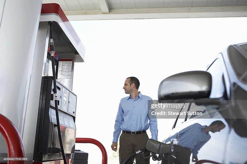 Business man at gas station filling his car