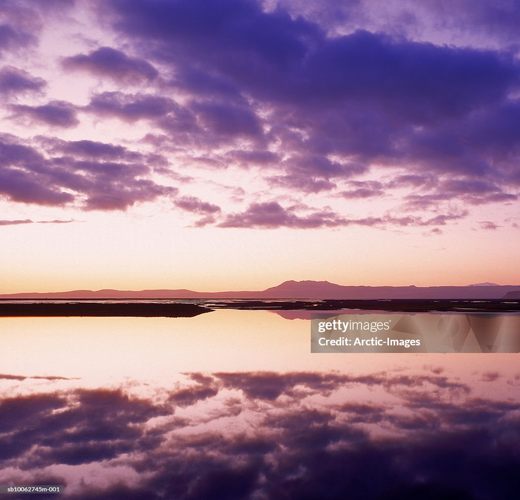 Clouds reflecting in lake at sunset