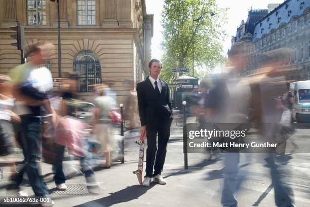 businessman holding skateboard in streets, blurred motion - blurred motion fotografías e imágenes de stock