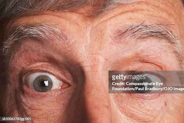 senior man with eyes wide open and raised eyebrows, portrait, close-up - compassionate eye stock pictures, royalty-free photos & images