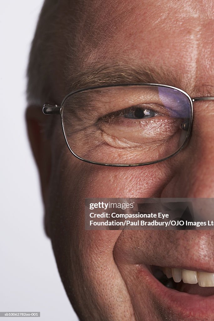 Mature man wearing spectacles, smiling, portrait, close-up of face