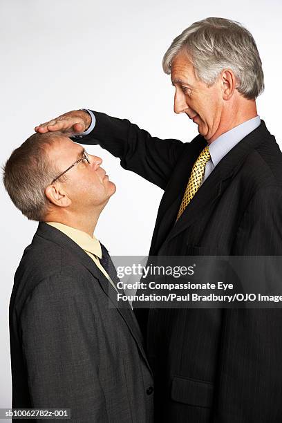 tall and short businessmen comparing height, profile - high up stock pictures, royalty-free photos & images