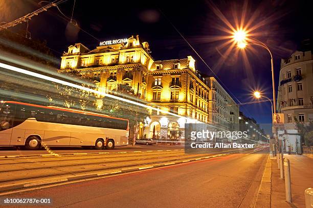 austria, vienna, coach travelling along road in city, night - coach bus photos et images de collection
