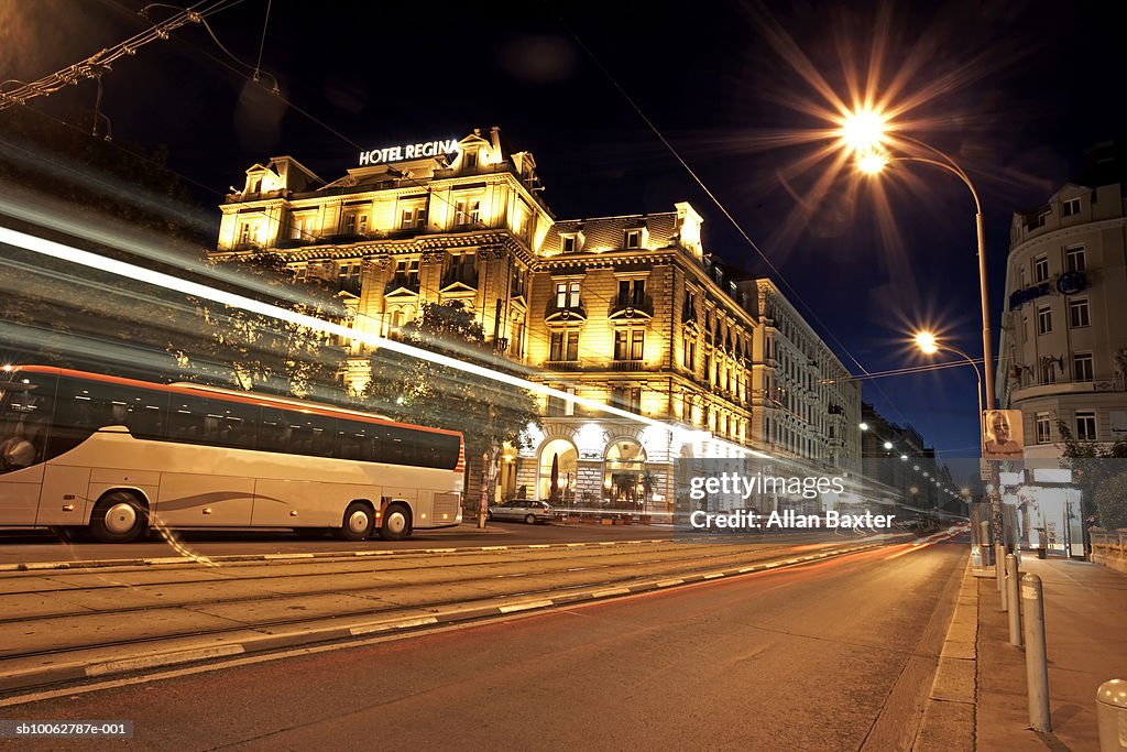 Austria, Vienna, coach travelling along road in city, night