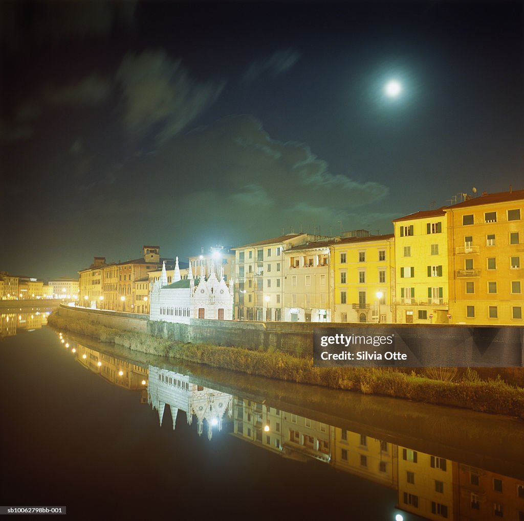 Italy, Pisa, houses on Arno River bank at night