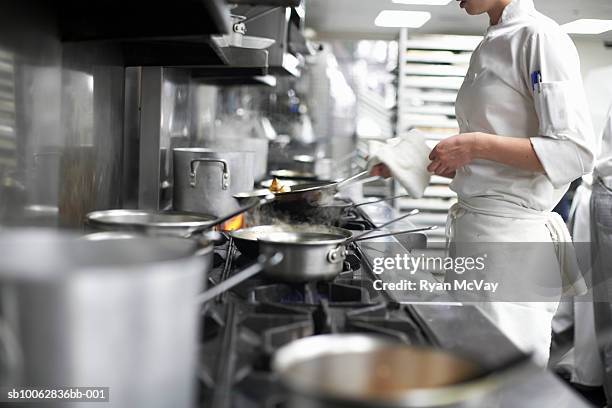chef cooking in commercial kitchen, mid section - uniforme de chef fotografías e imágenes de stock