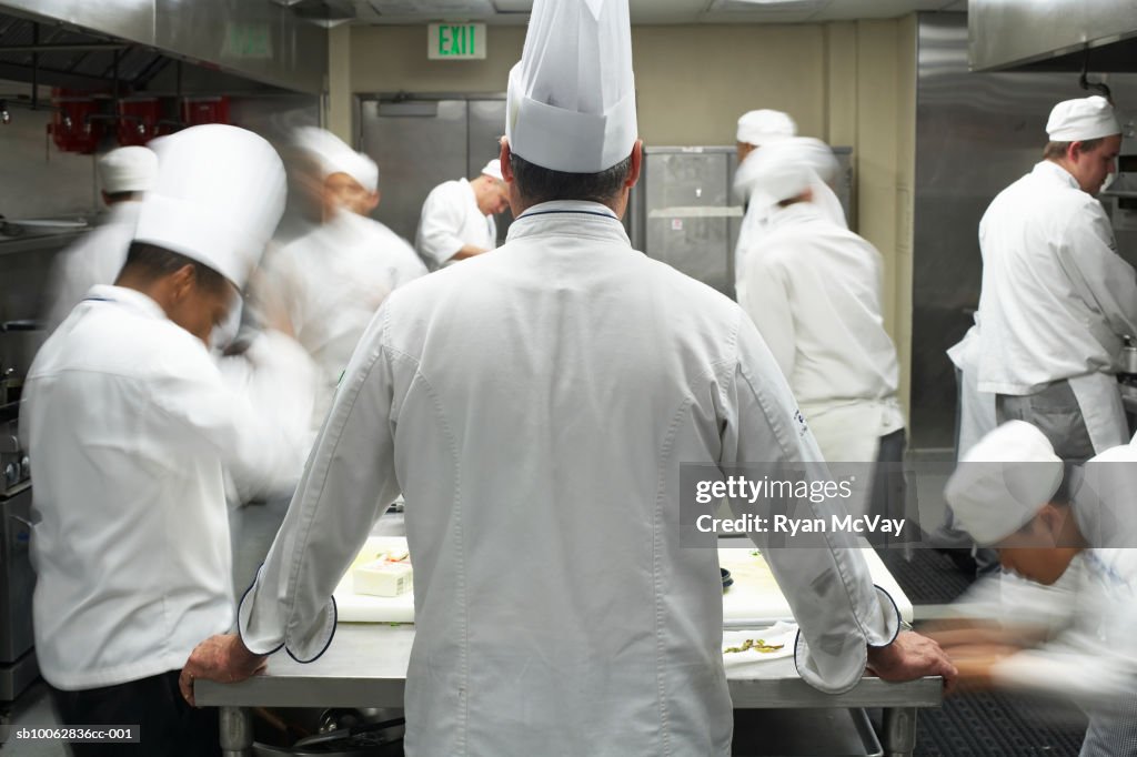 Chefs in commercial kitchen, blurred motion