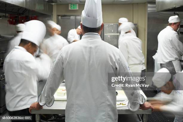 chefs in commercial kitchen, blurred motion - uniforme de chef fotografías e imágenes de stock