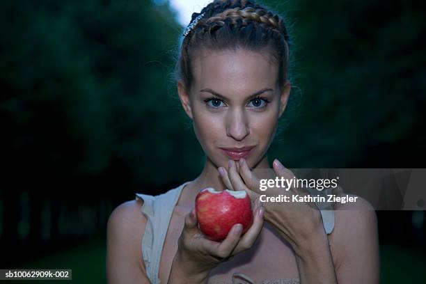 young woman holding apple, portrait, close-up - pomme croquée photos et images de collection