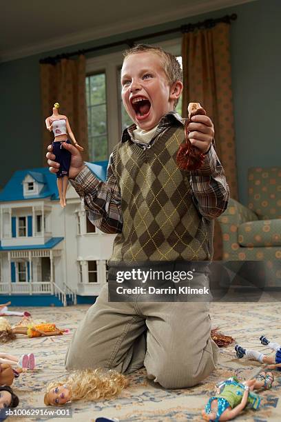 boy (6-7 years) holding decapitated dolls and yelling - muñeca juguete fotografías e imágenes de stock