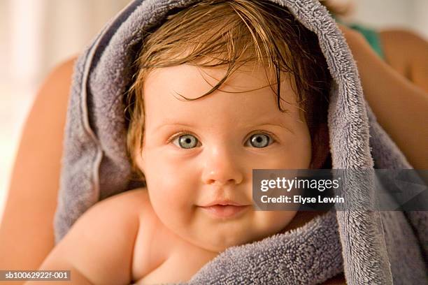 mother wiping in towel baby girl (6-9 months) after bath, close-up and focus on girl in foreground - envuelto en una toalla fotografías e imágenes de stock