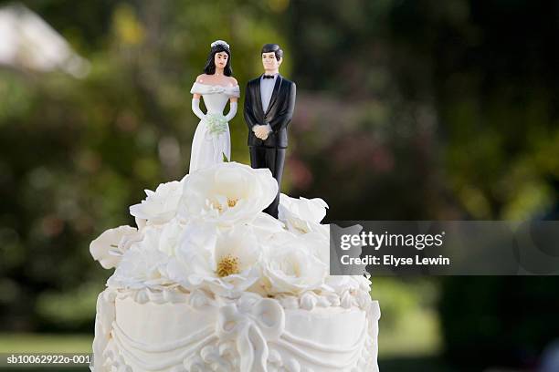 bride and groom figurines on top of wedding cake, close-up - wedding cake foto e immagini stock