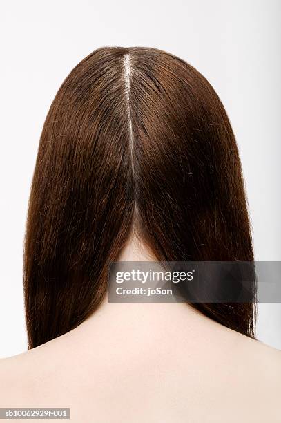 young woman with part in long brown hair, rear view - hair parting stockfoto's en -beelden