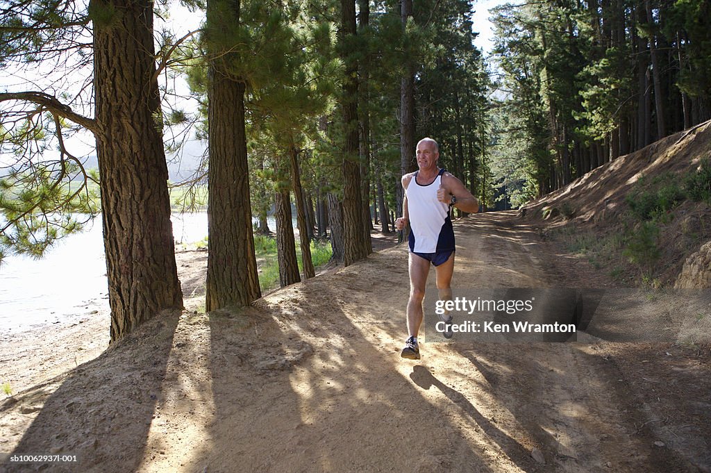 Mature man jogging in forest