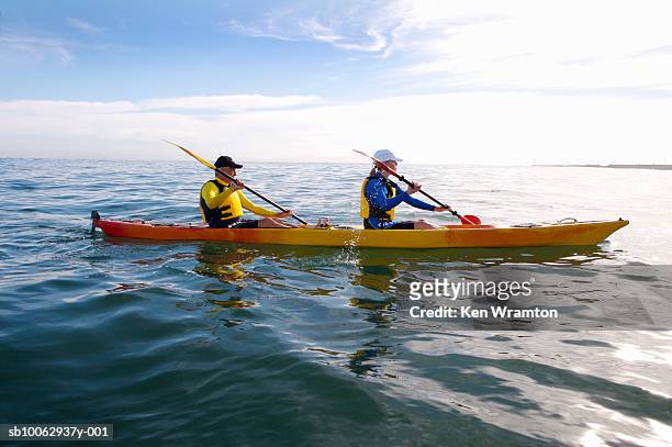 couple canoeing at sea, side view - paddla bildbanksfoton och bilder