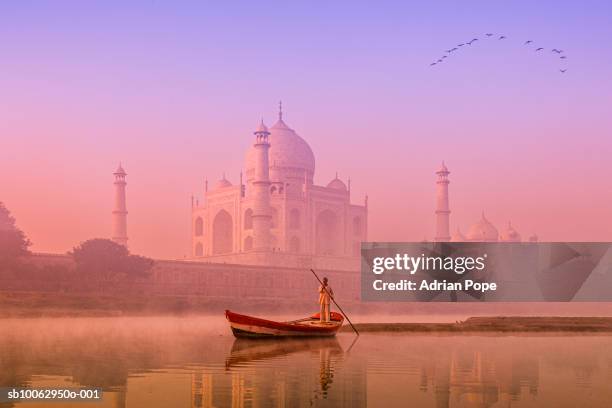 india, uttar pradesh, agra, yamuna river with boatman at dawn, taj mahal in background - アーグラ ストックフォトと画像