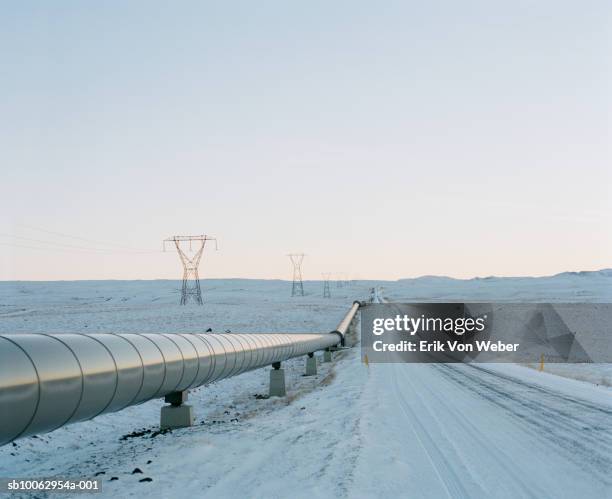 geo-thermal pipeline by snowy road - pipeline stock-fotos und bilder